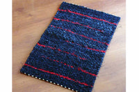 black denim and red twined rag rug using recycled materials